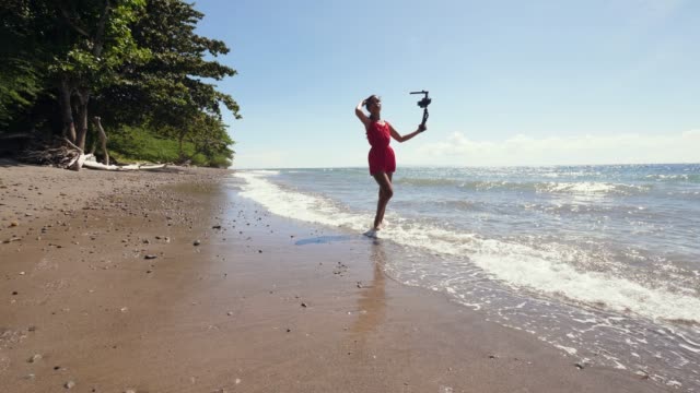 Ein-tausendjähriger-Vlogger,-der-am-Strand-spazieren-geht-und-Vlog-für-soziale-Medien-aufnimmt