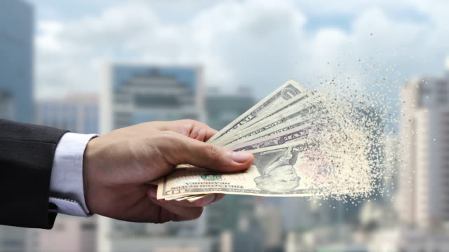Die-Verbreitung-von-Dollar-Papier-Währung-in-der-Hand-auf-Stadt-Hintergrund