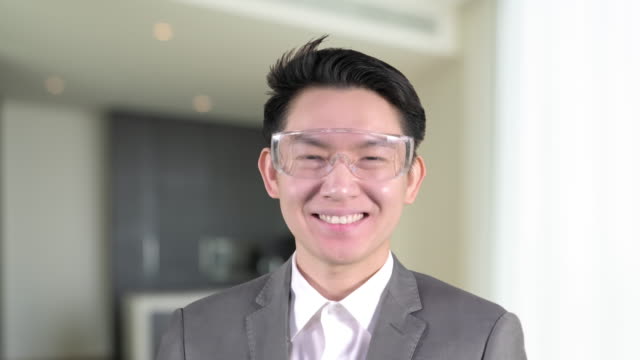 Hombre-de-negocios-asiático-sonriendo-usar-gafas-inteligentes-mucho-internet-de-cosa-interior-de-la-casa-desenfoque-fondo,-trabajo-de-negocios-desde-el-concepto-de-casa