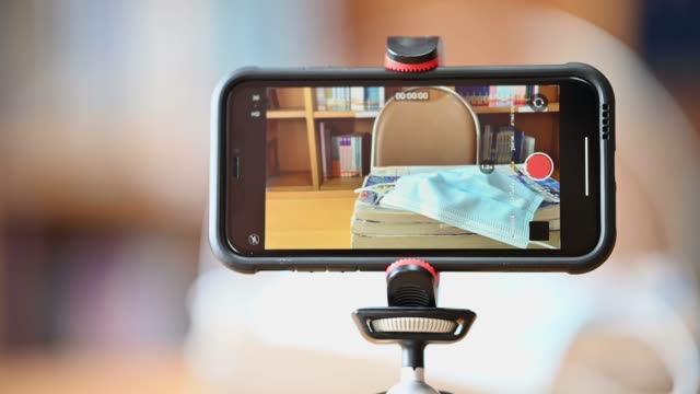 A-mobile-phone-mounted-on-a-tripod-is-used-to-teach-students-online-at-the-library.