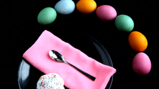 On-a-black-table-next-to-the-eggs-put-a-plate,-napkin-and-Easter-cake.