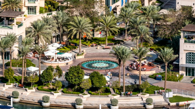 Brunnen-und-Palmen-timelapse-auf-der-Marina-walk,-während-des-Tages.-Dubai,-Vereinigte-Arabische-Emirate