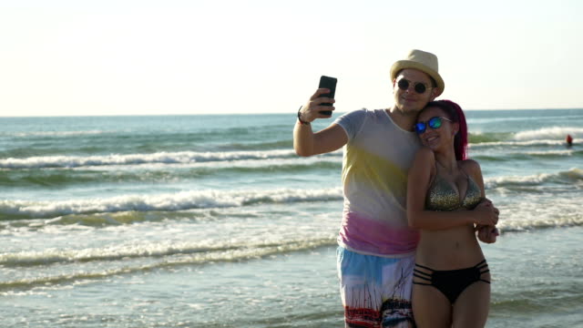 Happy-young-couple-taking-a-selfie-on-the-beach