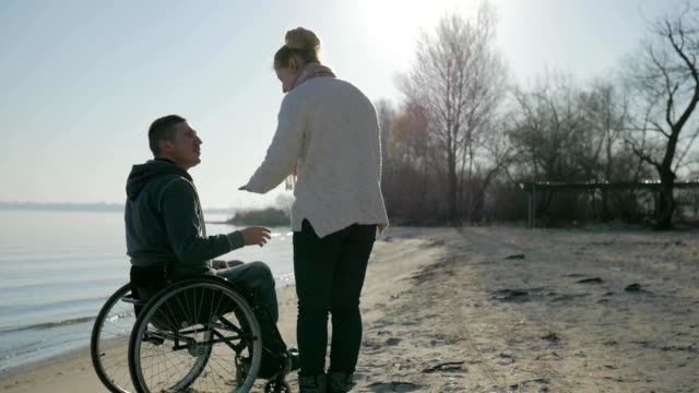 Man-in-wheelchair-and-girl-pray-for-healing,-disabled-man-and-girlfriend