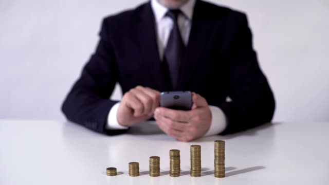 Mann-mit-mobile-app,-Berechnung-des-Einkommens-von-Kaution-oder-erfolgreiche-Investition