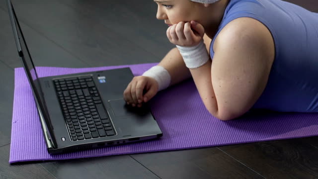 Chica-gorda-mentira-delante-del-ordenador-portátil,-mirando-tristemente-en-pantalla,-a-la-espera-de-mensaje