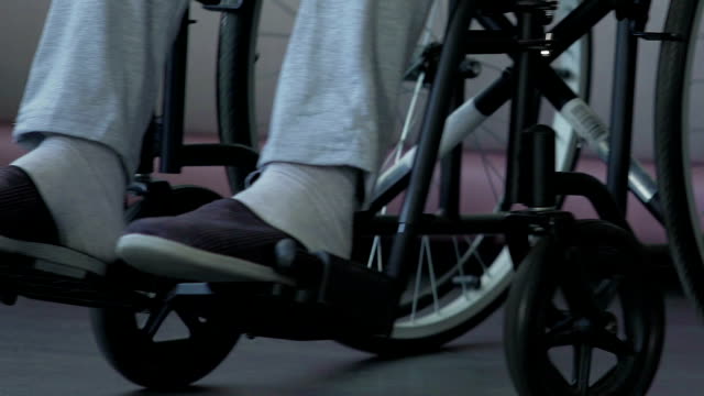 Füße-auf-Rollstühle-Schritt-Mann-treibt-Rollstuhl-vorwärts-bewegen