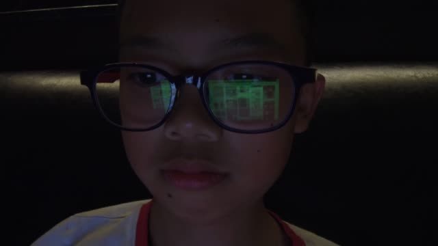 Asian-boy-using-computer-at-night-time.