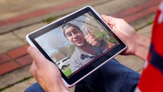 Man-beobachtet-eine-virale-Video-Vloggerin-außerhalb-auf-Tablet-PC