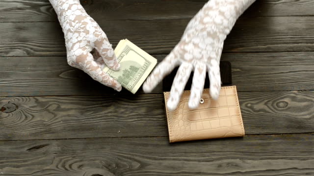 Woman's-hands,-in-white-lace-gloves,-count-the-US-dollars-banknotes.