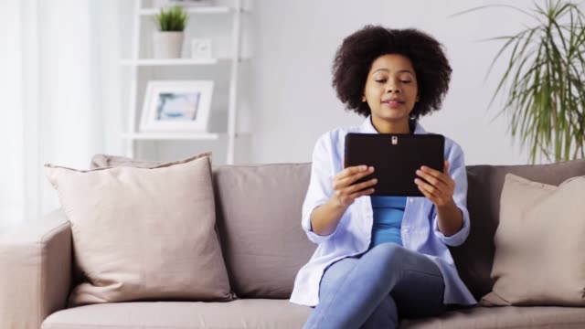 happy-afro-american-woman-with-tablet-pc-at-home