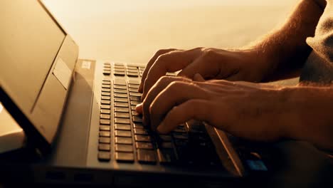 Close-up-young-man-working-on-laptop-outdoors