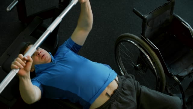 Hombre-con-discapacidad-haciendo-Press-de-pecho-con-barra