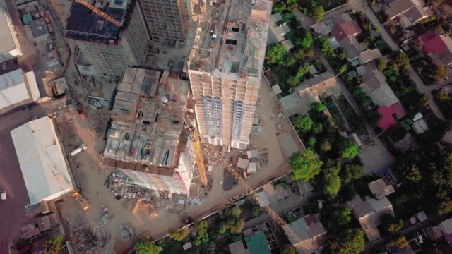 Aerial-drone-shot.-Construction-of-high-rise-buildings-in-the-developing-area-of-a-large-city.-Sunset-shot.-Span-above-the-construction-site.-Look-horizontally-down