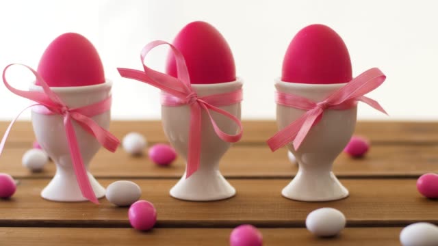 huevos-de-Pascua-en-los-titulares-y-caramelos-en-la-mesa-de-color-rosa