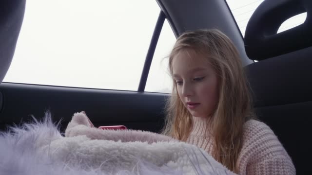 Young-girl-using-smartphone-in-the-car.