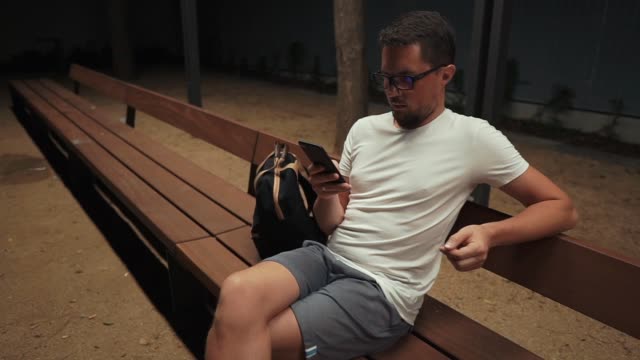 Hombre-que-sostiene-un-smartphone-en-la-noche.