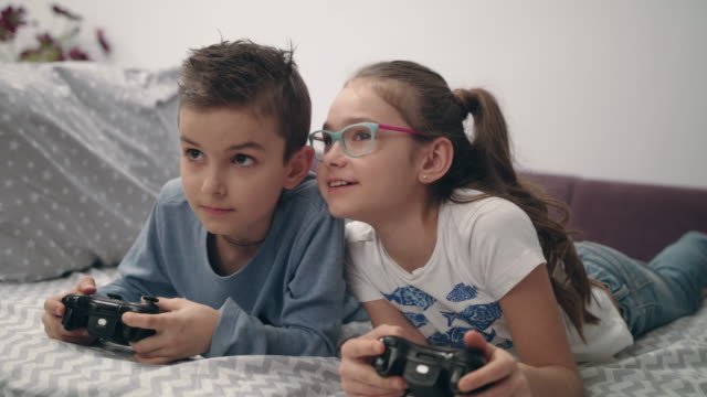 Felices-los-niños-jugando-video-juego-con-joystick-en-casa.-Consola-de-juegos-de-juego-de-amigos