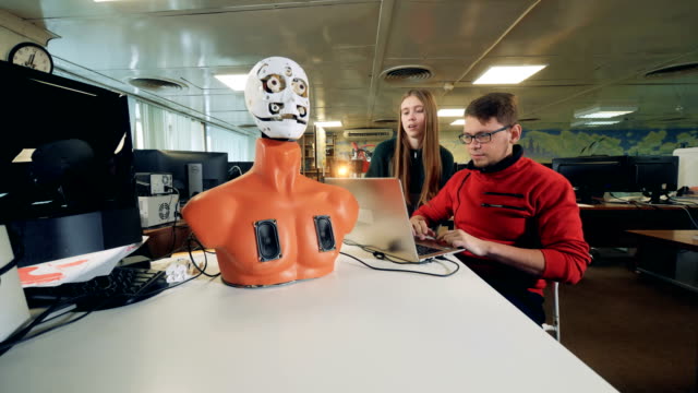 Junge-Ingenieure-manipulieren-einen-Cyborg-in-bewegte-seine-Gesichts-Organe