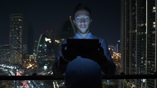 Kaukasischer-Mann,-der-digitales-Tablet-für-das-Internet-und-Kommunikation-mit-Stadtbilding-Hintergrund-nutzt