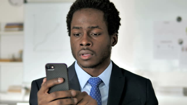 Excited-Happy-African-Businessman-Using-Smartphone