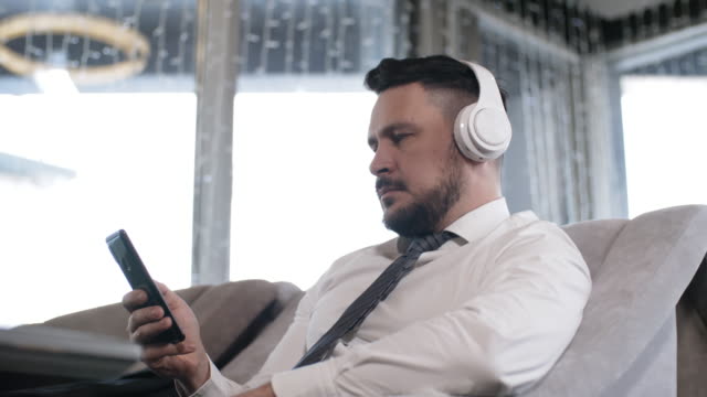 Businessman-in-Headphones-Using-Smartphone