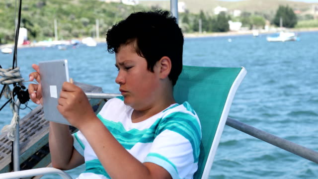 Junge-mit-digitalen-Tablet-Computer-auf-Yacht