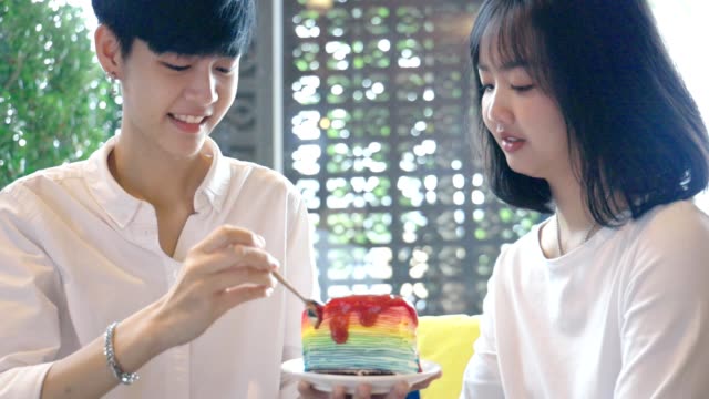 Young-Asian-Lesbian-Couple-Feeding-Sweet-Rainbow-Cake,-LGBT-Love-Moment-Slow-motion
