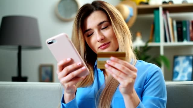 Woman-making-online-payment-with-credit-card-usiing-app-and-smartphone,-online-shopping,-lifestyle-technology.-Girl-enters-the-bank-card-number-into-the-smart-phone,-easy-pay-using-mobile-device