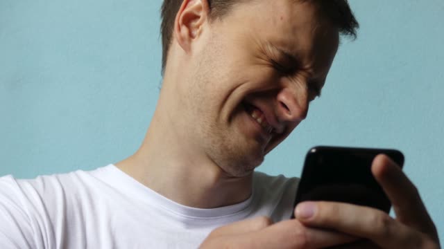 Close-up-of-man-using-smartphone.-Young-man-with-tablet-computer.-A-man-at-day-on-social-networks-using-a-smartphone.-Looking-Satisfied.-Male-is-touched-looking-at-the-phone