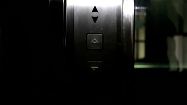 La-mano-de-una-joven-presiona-el-botón-de-llamada-del-ascensor.