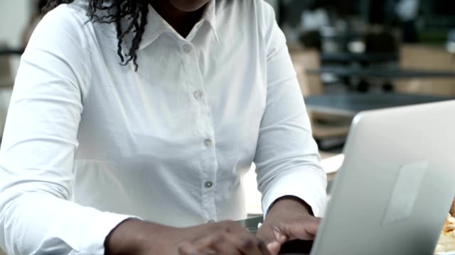 Attraktive-afroamerikanische-Frau-arbeiten-mit-Laptop.