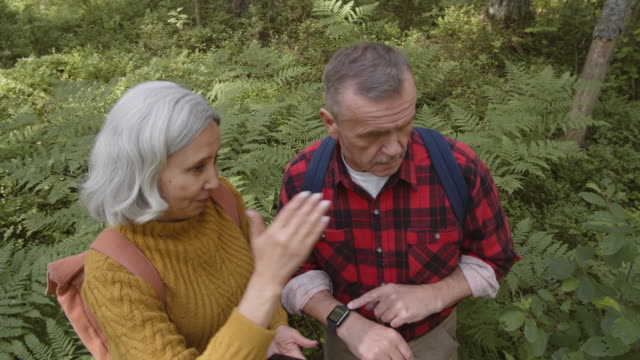 Älteres-Familienpaar-mit-modernen-Gadgets-im-Wald