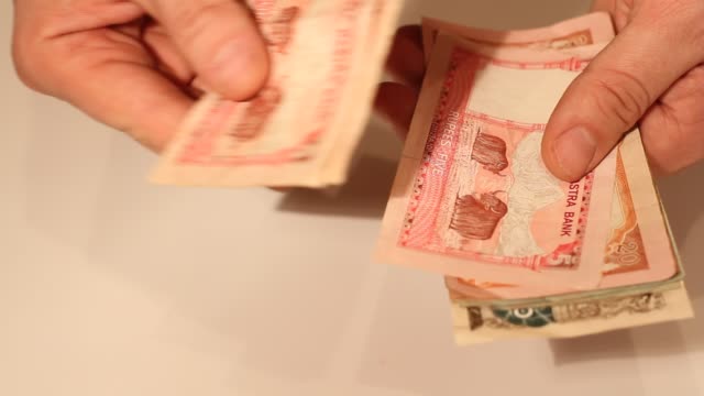 Die-Hände-des-Mannes-zählen-nepalesische-Rupee-Banknoten.-Nationale-Währung-Nepals-(NPR)