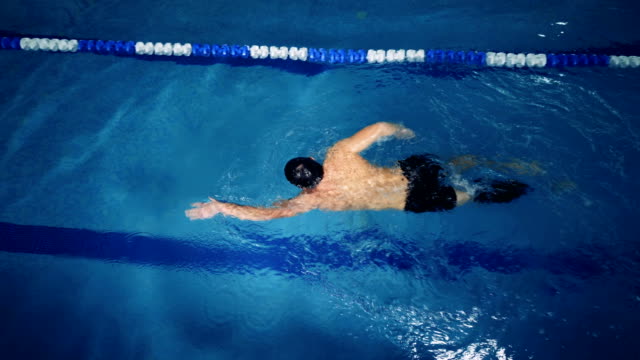 Top-view-of-a-male-swimmer-with-a-prosthetic-leg-in-a-swimming-pool