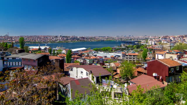 Panoramic-top-view-with-red-roofs-of-houses-and-mosques-behind-Golden-Horn-timelapse-in-Istanbul,-Turkey