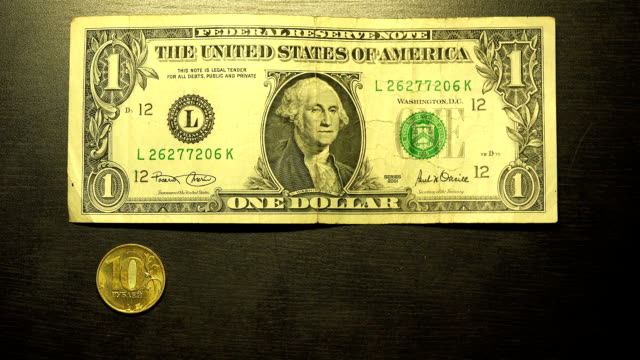 Drei-zehn-Münze-und-einem-US-Dollar-auf-einem-schwarzen-Tisch-grün