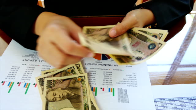 Close---up-working-woman--hand-count-money-with--financial-report-in-bussiness-and-financial-concept.