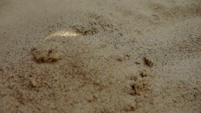 Goldene-Bitcoin-Münze-ist-aus-Sand-ausgegraben.