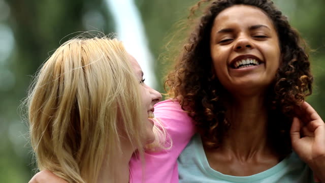 Gay-female-couple-smiling,-embracing-tightly-while-posing-in-front-of-camera