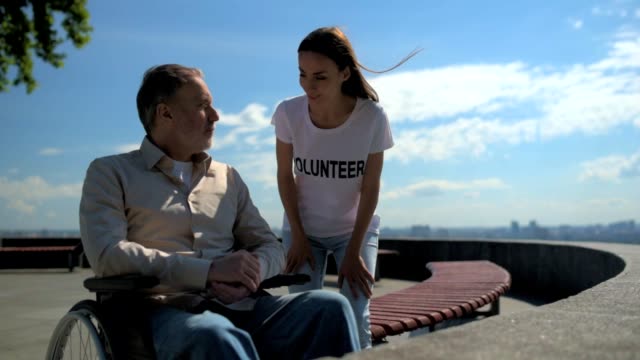 Wheelchaired-Alter-Mann-sprechen-mit-einer-weiblichen-Freiwilligen