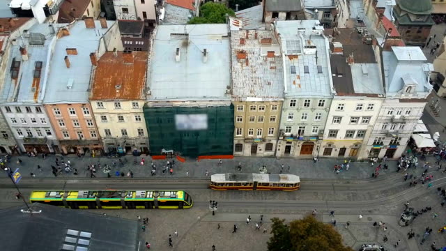 Old-and-modern-trams-moving-in-Lviv-narrow-street,-past-intersecting-with-future