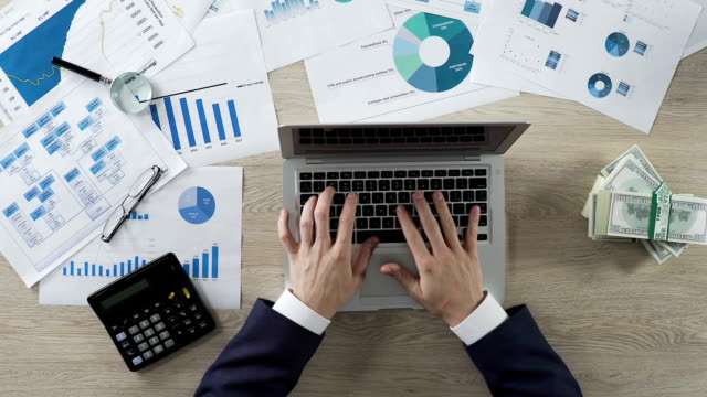 Büro-Mitarbeiter-auf-Laptop-am-Schreibtisch,-Unternehmensanalyse-Einnahmen,-Rechnungen-beiseite