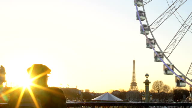 Turistas-observando-la-puesta-de-sol-desde-la-noria,-la-Torre-Eiffel-en-el-fondo-de-rotación
