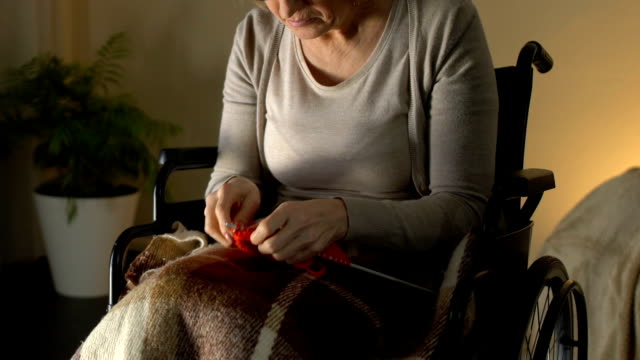 Disabled-woman-with-poor-sight-trying-to-knit,-annoyed-and-helpless-in-old-age