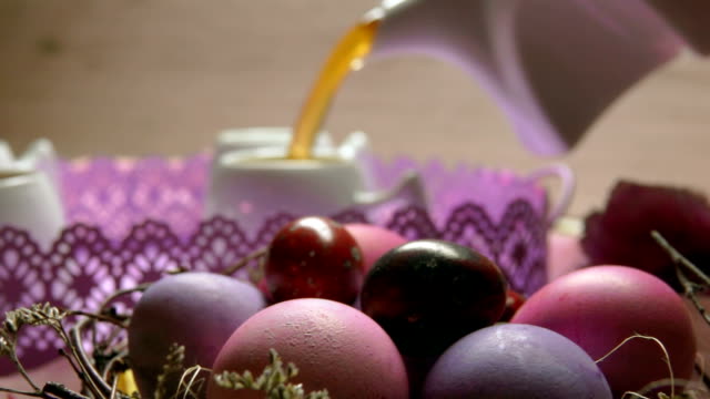 A-colored-pink-Easter-egg-lies-on-the-background-of-a-tea-poured-in-the-cup