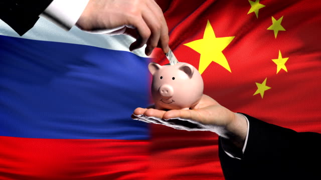 Russland-Investitionen-in-China,-Hand,-Geld-im-Sparschwein-auf-Flagge-Hintergrund