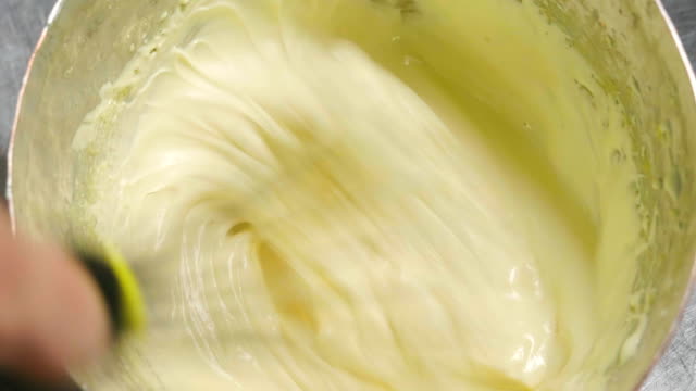 Un-pastelero-profesional-prepara-una-crema-batiendo-bío-huevos-frescos-en-una-vasija-para-hacer-un-pastel.