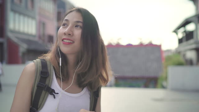 Mujer-de-blogger-asiático-para-mochileros-con-smartphone-para-el-chat,-revise-las-redes-sociales-y-escuchar-música-mientras-viaja-a-Chinatown-en-Beijing,-China.-Estilo-de-vida-mochila-concepto-de-vacaciones-de-viajes-turísticos.