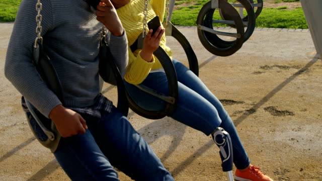 Happy-couple-using-mobile-phone-in-the-park-4k